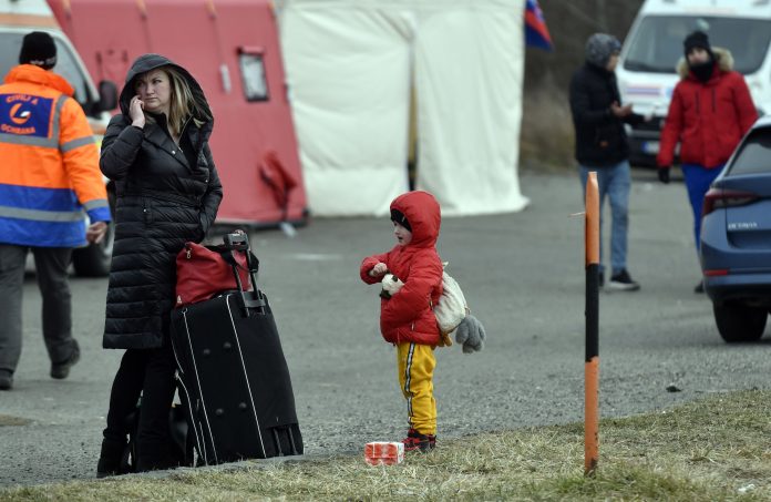 Na snímke utečenci z Ukrajiny čakajú na odvoz na hraničnom priechode vo Vyšnom Nemeckom. FOTO TASR - Roman Hanc