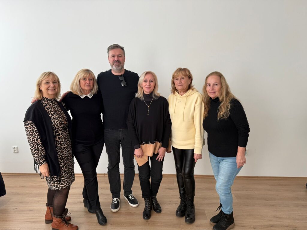 Účastníci divadelného workshopu pózujú na jednej fotke - režisér a päť herečiek.