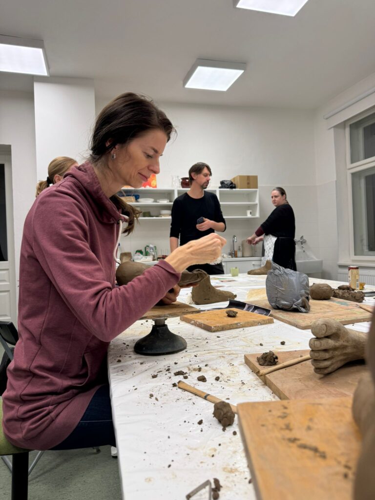 Účastníčka workshopu modelujúca z hliny