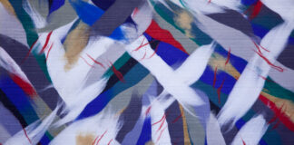 Abstraktný obraz z bielych, tmavomodrých, bielych a červených škvŕn vytvorený z ovčej vlny.