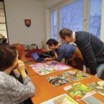 Tri ženy konzultujú výtvarné diela.