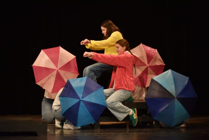 Deti hrajúce divadlo, s dáždnikmi.