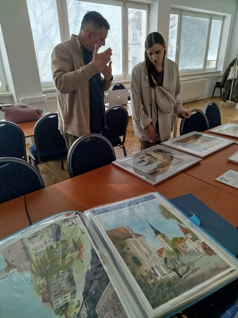 Muž a žena konzultujú výtvarné diela. 