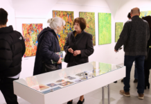 Dve staršie ženy prezerajúce si výstavu.