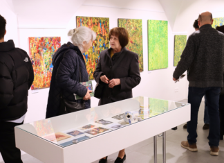 Dve staršie ženy prezerajúce si výstavu.