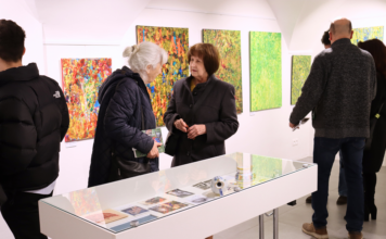 Dve staršie ženy prezerajúce si výstavu.