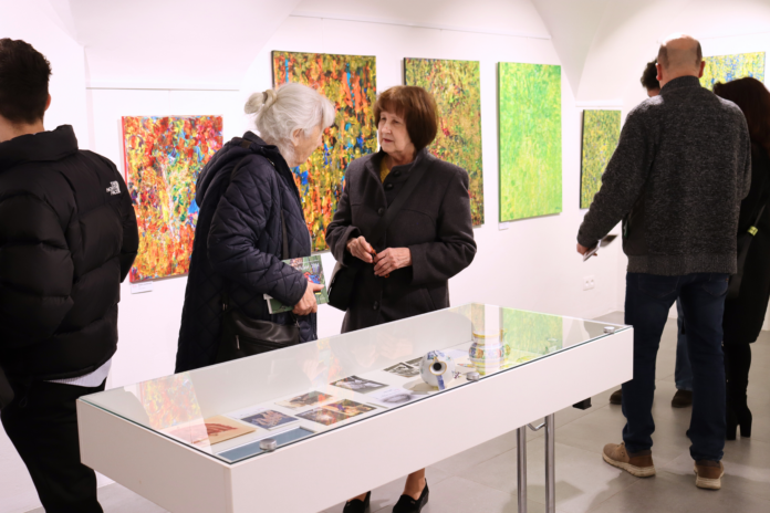 Dve staršie ženy prezerajúce si výstavu.